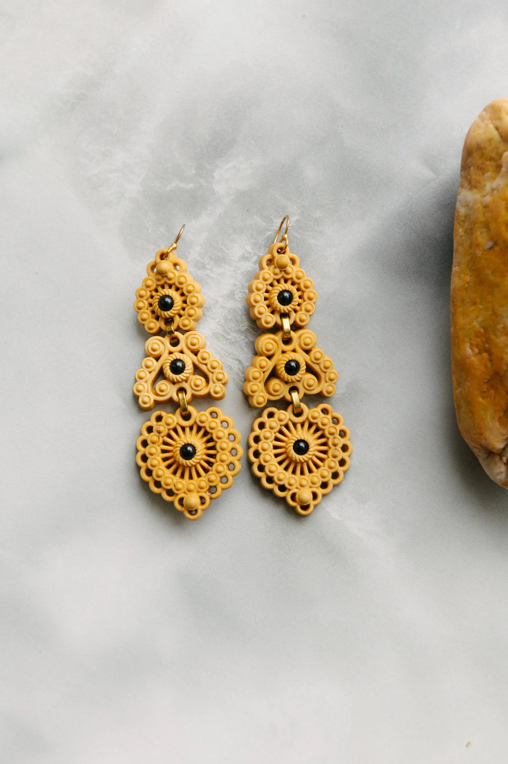 Pendientes largos de boj con turmalina, motivos florales y colgantes dorados.